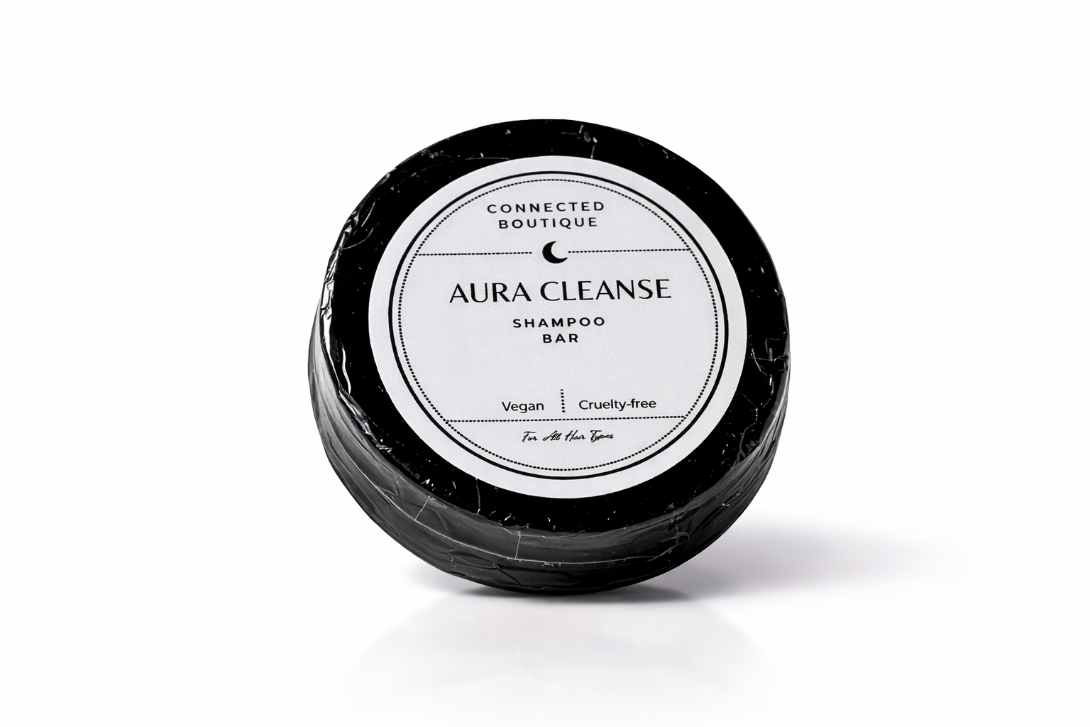 Shampoo bar in a black container with 'Aura Cleanse' label on a white background