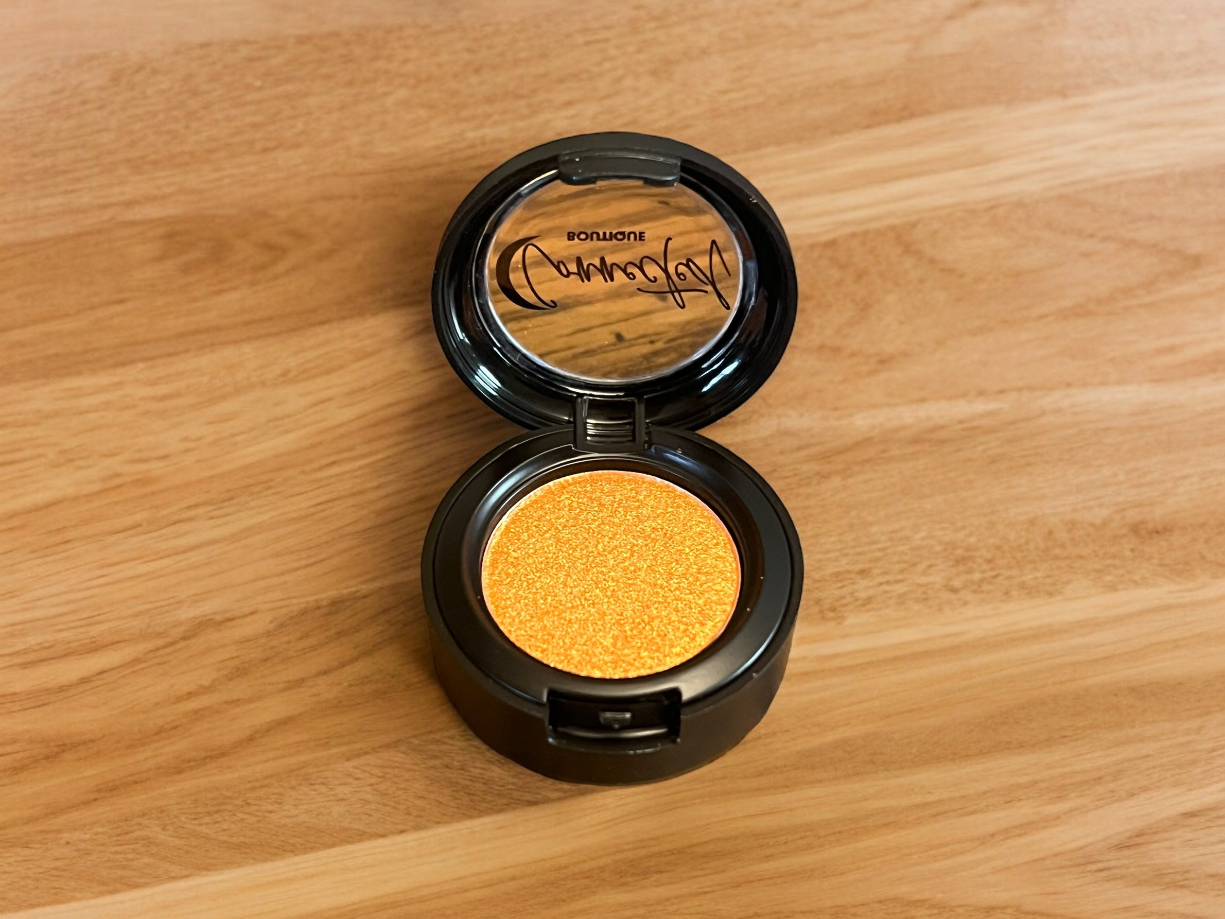 “Astral Kiss” orange shimmer single eyeshadow